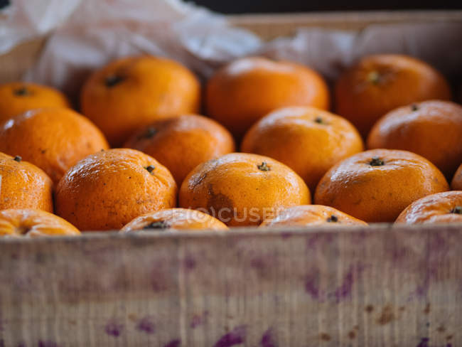 Close-up of ripe oranges in wooden box — Stock Photo