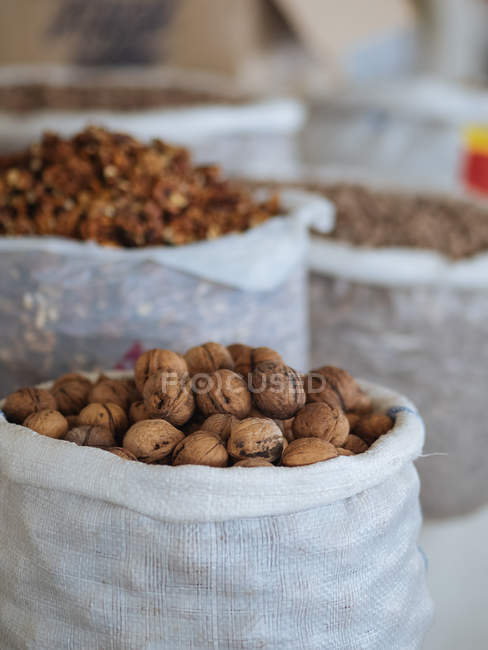 Fabric bags of dried walnuts at farmer market — Stock Photo