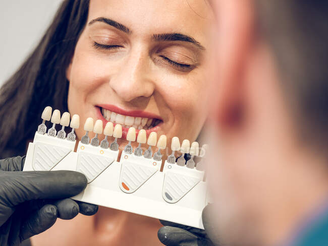 Dentiste choisir la couleur de la prothèse dentaire — Photo de stock