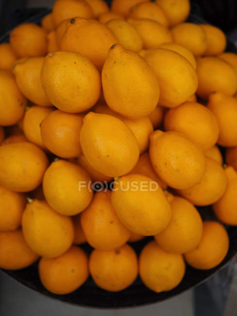 Heap of ripe fresh lemons on scales — Stock Photo