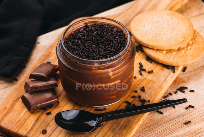 Postre de mousse con chocolate en tarro sobre tabla de madera - foto de stock
