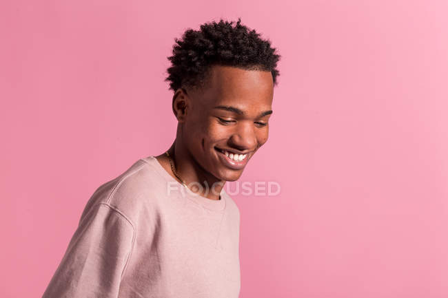 Smiling hipster black man posing on pink background — Stock Photo