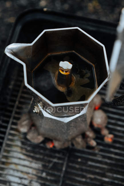 Caffè in caffettiera in cima al carbone caldo in piastra — Foto stock