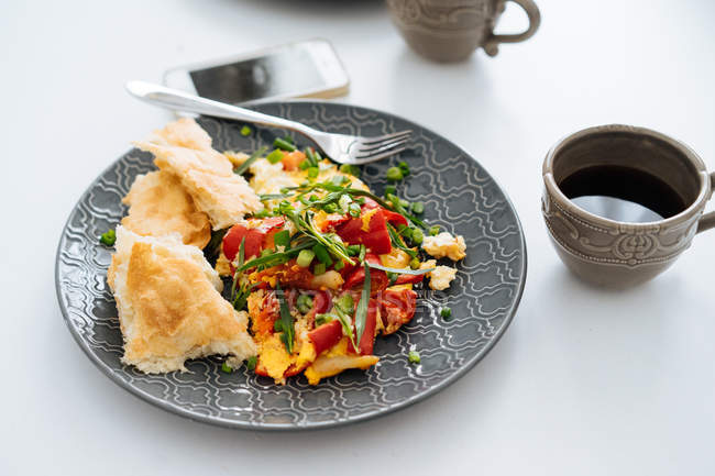 Omelete frito com legumes picados e pão no prato — Fotografia de Stock