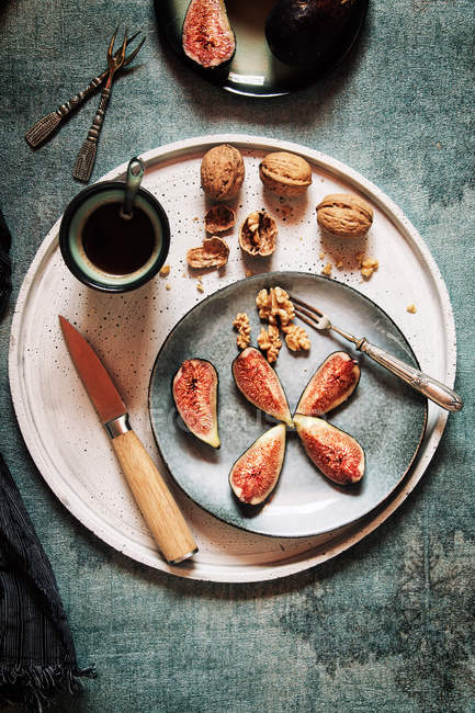 Свежие инжиры на тарелке с орехами — стоковое фото