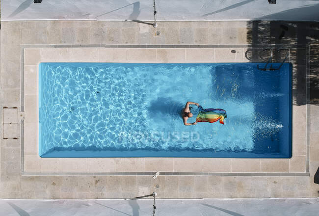 Gay man with gay pride flag in swimming pool. — Stock Photo