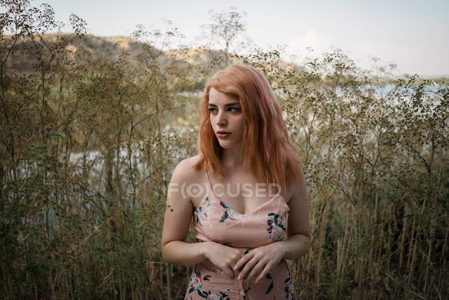 Ruiva jovem mulher em vestido ornamental posando na natureza — Fotografia de Stock
