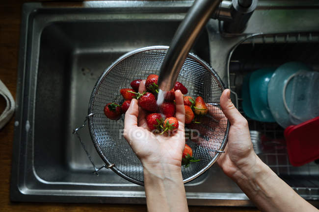 Mãos humanas lavar morangos sob torneira pia — Fotografia de Stock
