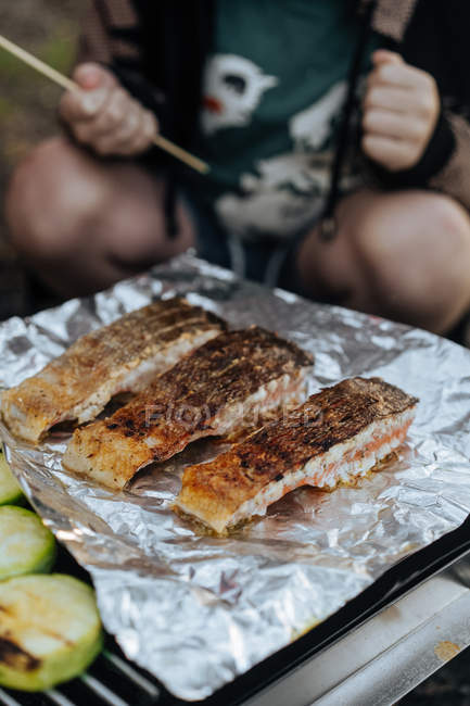 Gros plan de morceaux juteux de filets de saumon sur une grille en plein air — Photo de stock