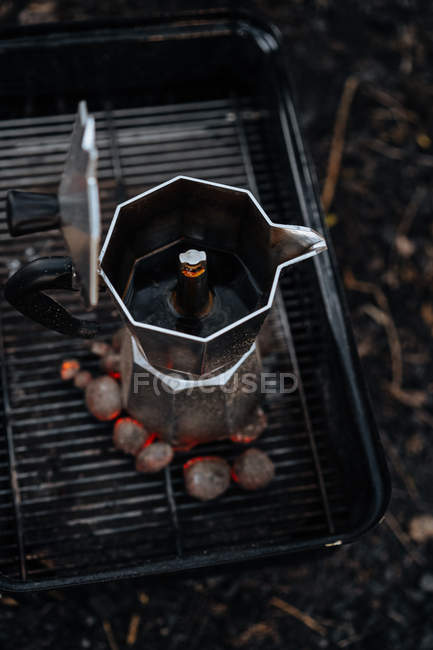 Кофе в кофеварке на вершине теплого угля в сковороде — стоковое фото