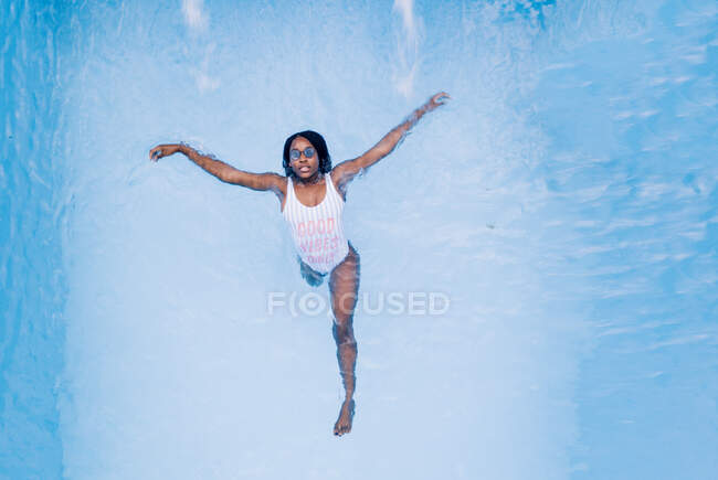 Bella donna africana in costume da bagno in piscina. — Foto stock