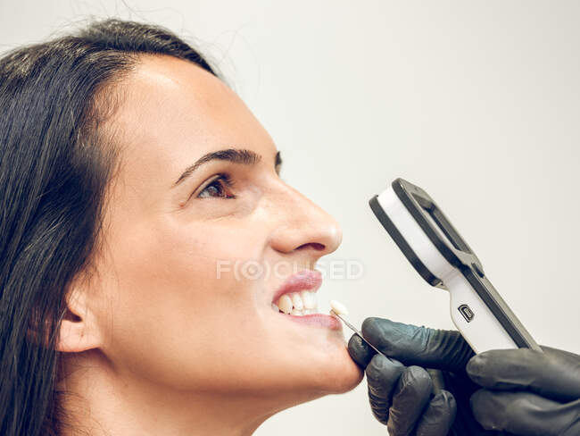Hand of dentist choosing denture dye for woman — Stock Photo