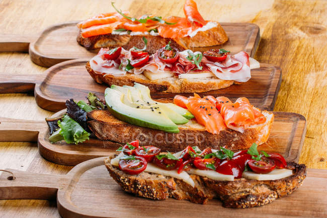Асортимент поживних різних бутербродів на дерев'яній дошці — стокове фото