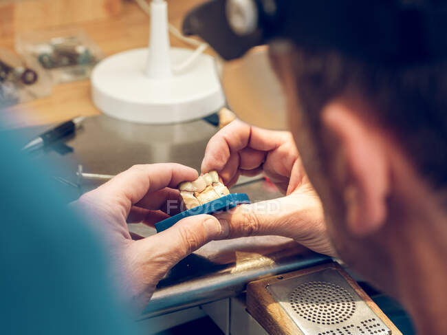 Hands of technician making denture — Stock Photo