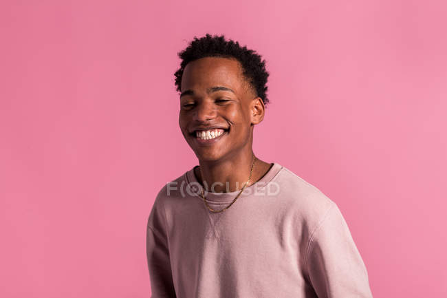 Sonriente hipster negro hombre posando sobre rosa fondo - foto de stock