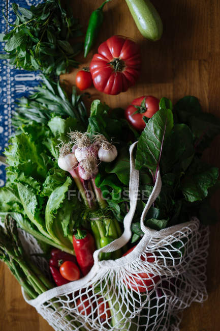 Verduras y verduras frescas sobre una mesa de madera - foto de stock