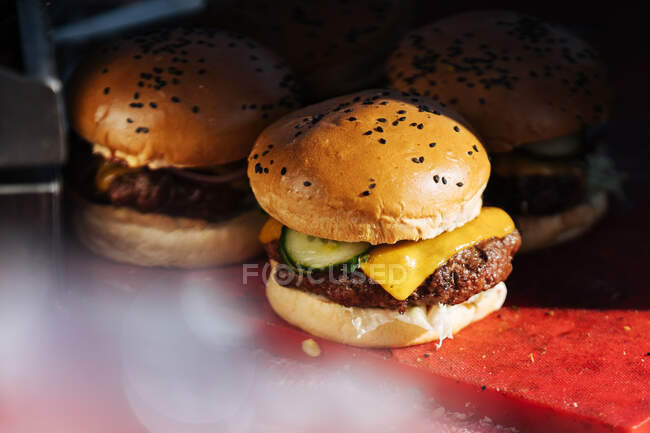 Close-up of freshly made hamburgers with juice patties and cheese served on counter in street food stall — Stock Photo