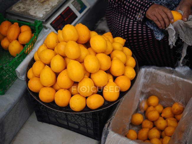 Vendor selling and wiping lemons at farmer market — Stock Photo