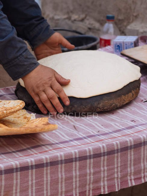 Mains féminines feuille à rouler de la pâte sur planche en bois — Photo de stock
