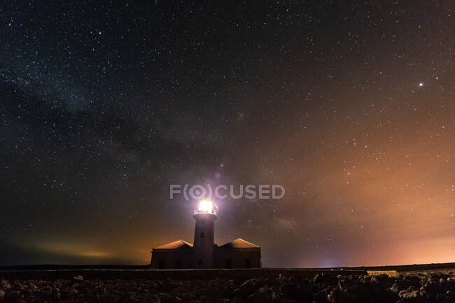 Lighthouse shining in the night of stars. Cavalleria, Menorca, Spain — Stock Photo