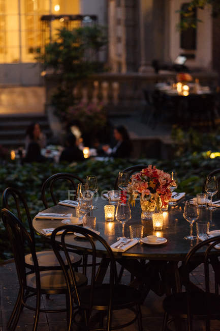 Apparecchiare la tavola decorata con candele e fiori di notte sul cortile — Foto stock