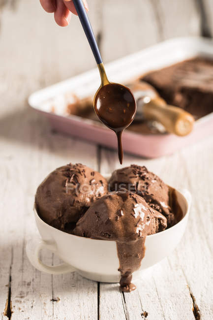 Dripping homemade ice cream in bowl with chocolate — Stock Photo