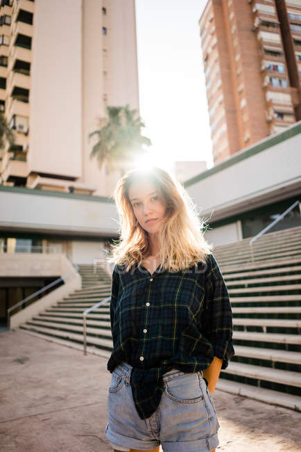 Блондинка молода жінка стоїть перед сходами на вулиці — стокове фото