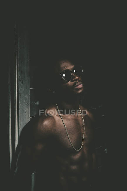 Fiducioso uomo in topless in occhiali da sole in posa da parete graffiti — Foto stock