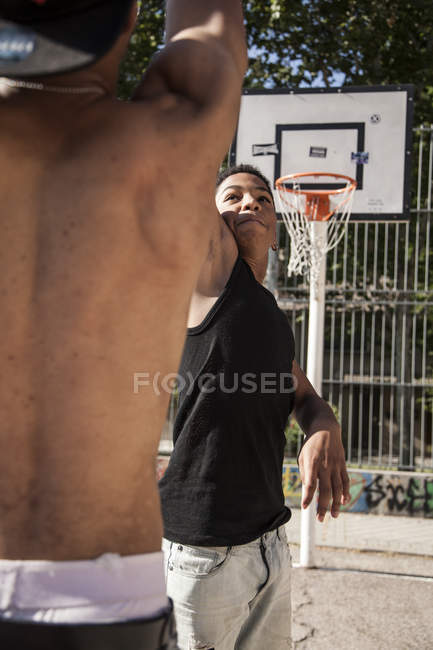 Young brothers playing basketball in court outdoors — Stock Photo
