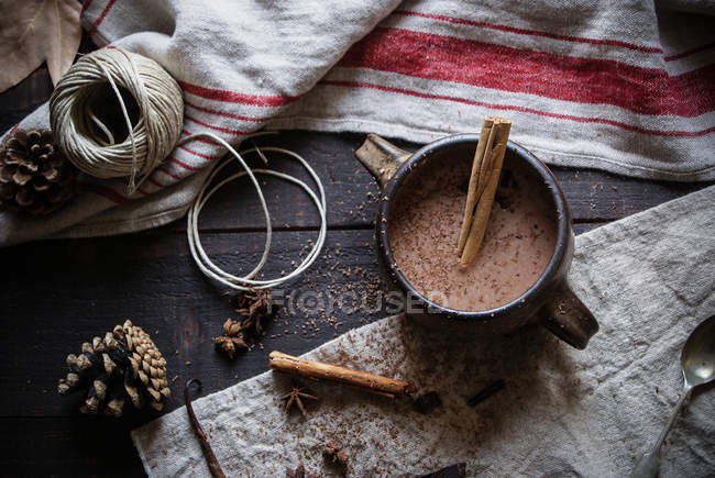 Chocolate quente com canela na caneca no fundo rústico — Fotografia de Stock
