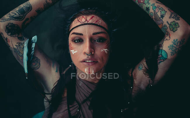 Attraente giovane donna con disegni tradizionali indiani sul viso rilassante in acqua con gli occhi chiusi — Foto stock