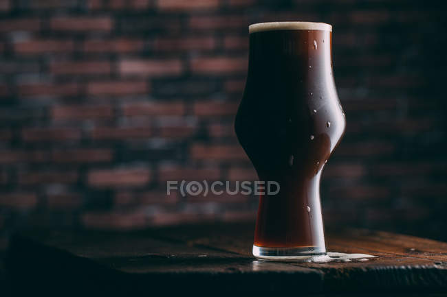 Stout beer in glass on dark background — Stock Photo