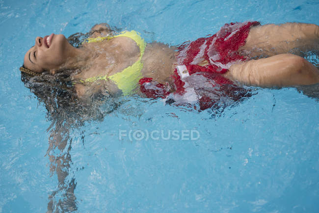 Mulher se divertindo na piscina com bandeira americana — Fotografia de Stock