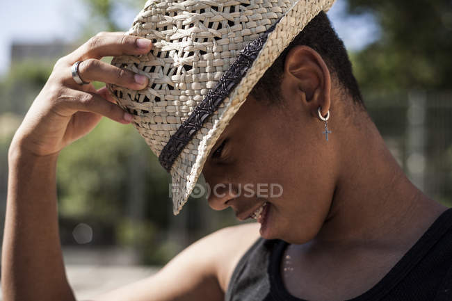Afro joven posando con sombrero de paja al aire libre - foto de stock