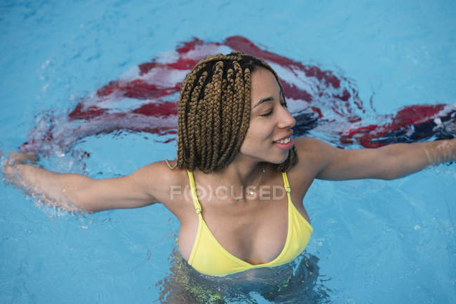 Mulher de pé na piscina com bandeira americana — Fotografia de Stock
