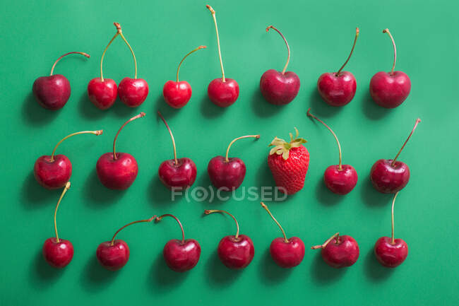 Vista dall'alto di un gruppo di ciliegie su sfondo verde — Foto stock
