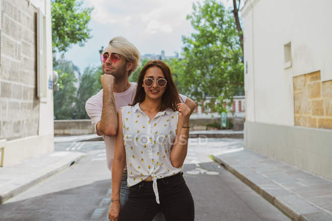 Male and female friends in sunglasses posing on street — Stock Photo