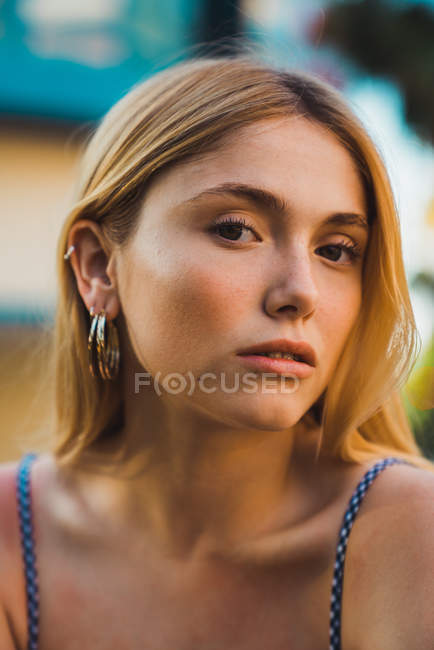 Porträt einer blonden jungen Frau, die im Freien in die Kamera blickt — Stockfoto