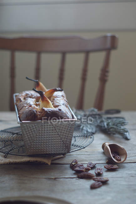 Pastel de pera recién horneado delicioso en bandeja para hornear en mesa de madera - foto de stock