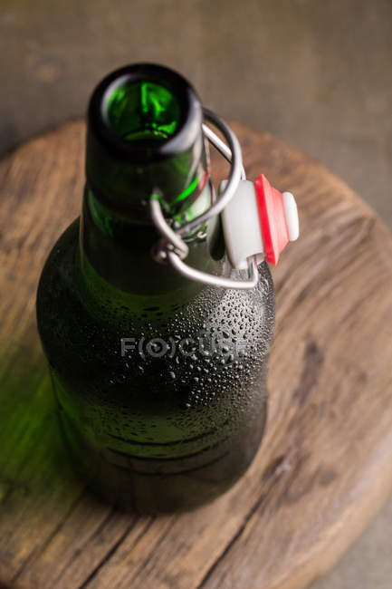 Kalte Bierflasche auf Holzbrett — Stockfoto