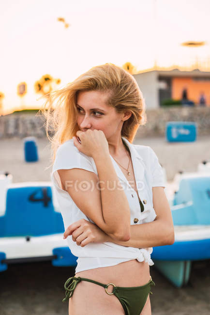 Блондинка стоїть на пляжі і дивиться через плече — стокове фото