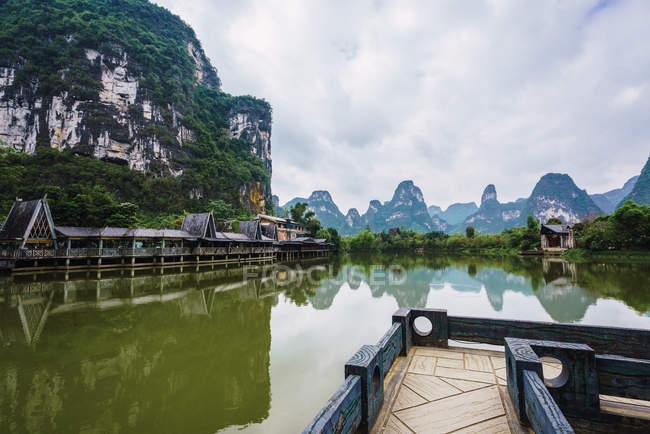 Planchers en bois à travers la rivière Quy Son sous un ciel nuageux, Guangxi, Chine — Photo de stock