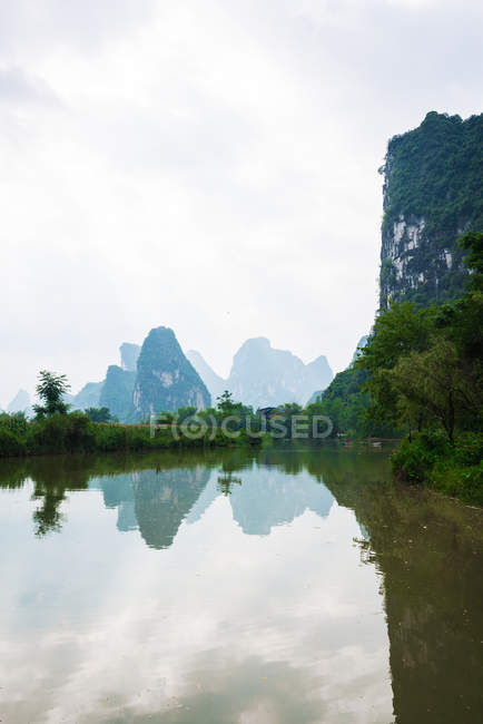 Ruhige Quy Sohn Fluss und Silhouette der Berge im Hintergrund, Guangxi, China — Stockfoto