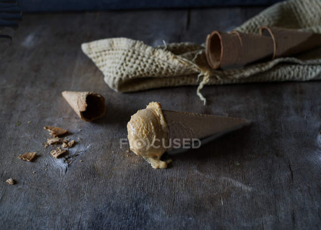 Sorvete saboroso em cone de açúcar crocante na mesa de madeira cinza — Fotografia de Stock