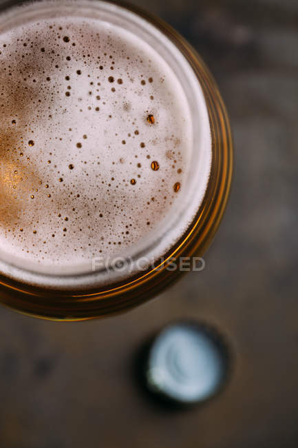 Primer plano del vaso de cerveza sobre fondo oscuro - foto de stock