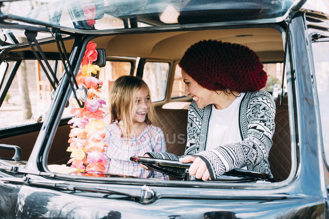 Young woman and blond girl driving old car — Stock Photo