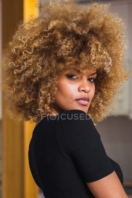 Ethnic curly woman in bodysuit looking at camera — Stock Photo