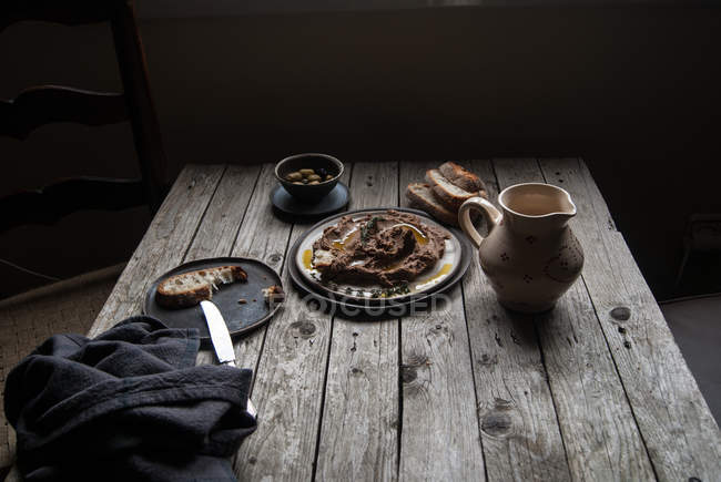 Чечевица паштет на тарелке на деревенском деревянном столе — стоковое фото