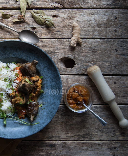 Смажені баклажани і рис зі спеціями в тарілці на сільському дерев'яному столі — стокове фото