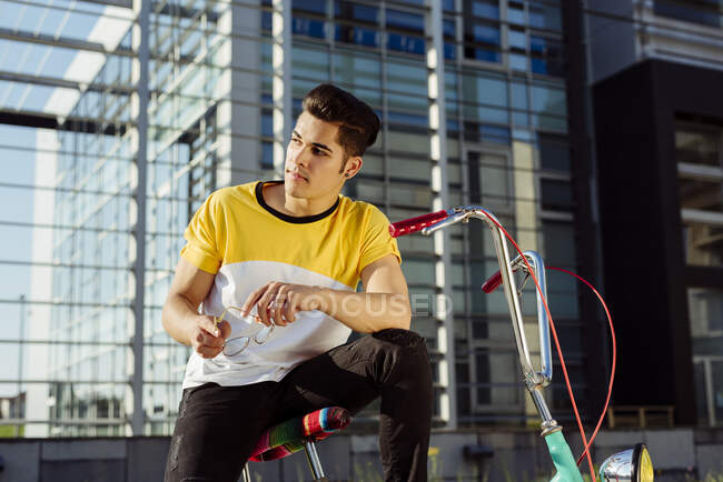 Привлекательный молодой человек сидит на винтажном велосипеде — стоковое фото